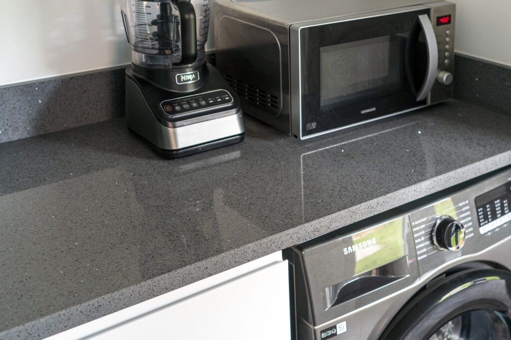 Grey Starlight Quartz worktop close-up with subtle sparkle flecks beside kitchen appliances