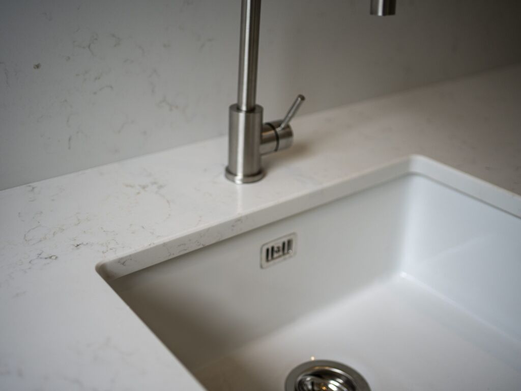 Carrara Quartz worktop around a white inset sink in a contemporary laundry room