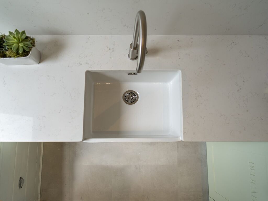 Carrara Quartz worktop with succulent arrangement beside the sink in a laundry room