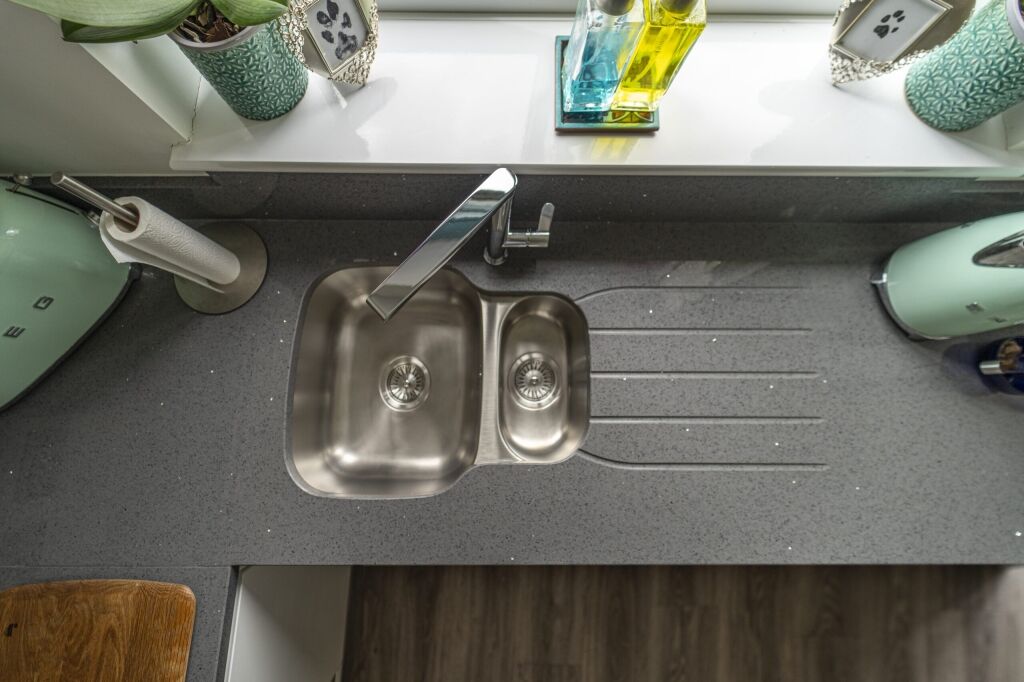 Grey speckled Quartz worktop with inset sink and drainer grooves shown from above