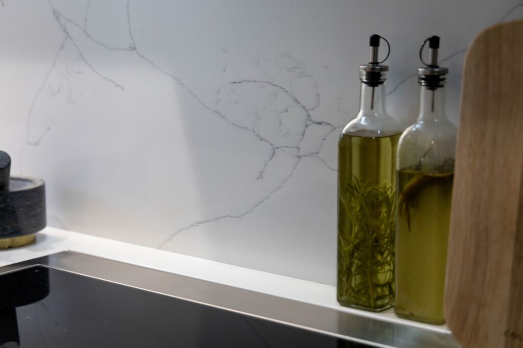 White Macaubus Quartz splashback and worktop detail showing subtle veining behind oil bottles
