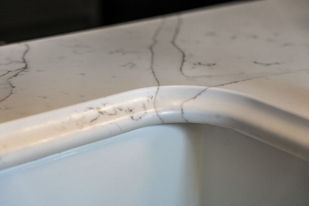 Gold Calacatta worktop with curved sink edge and warm veining