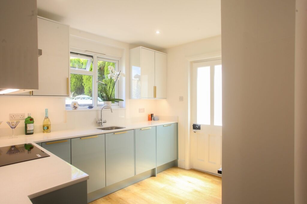 Bright kitchen with Dover White Quartz worktops along the main run, showing a smooth white surface finish