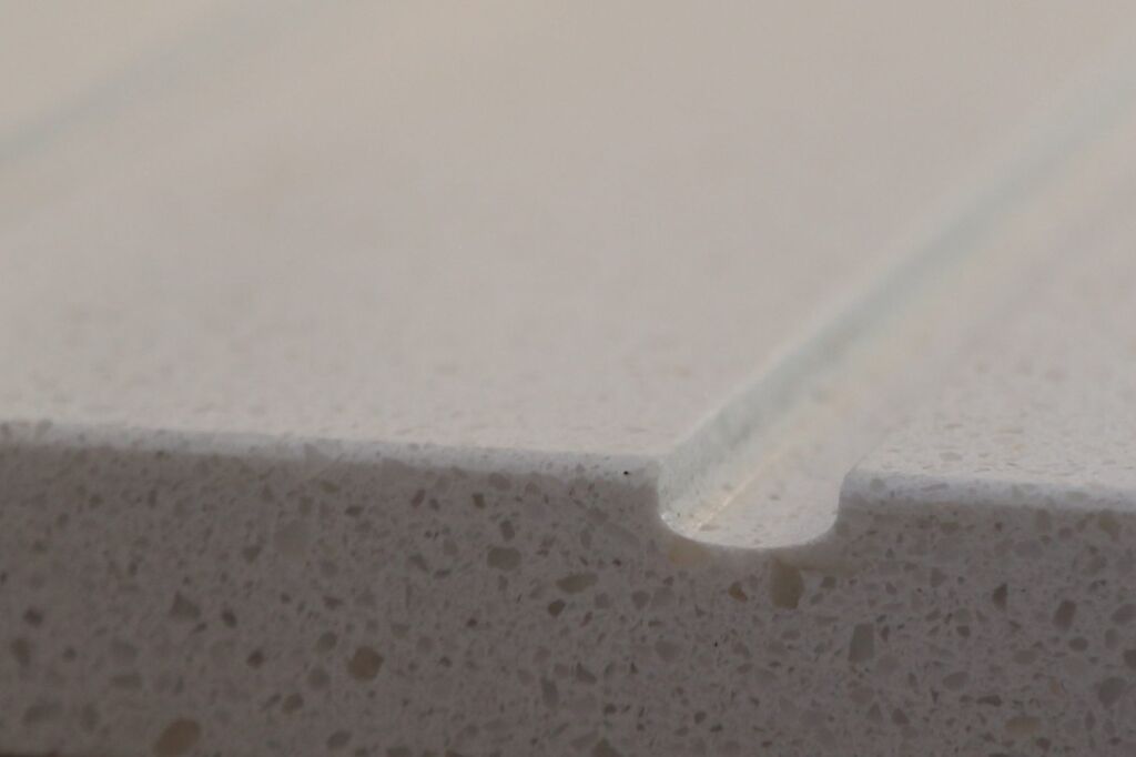 Close-up of Dover White Quartz worktop edge showing a smooth finish and fine speckled texture
