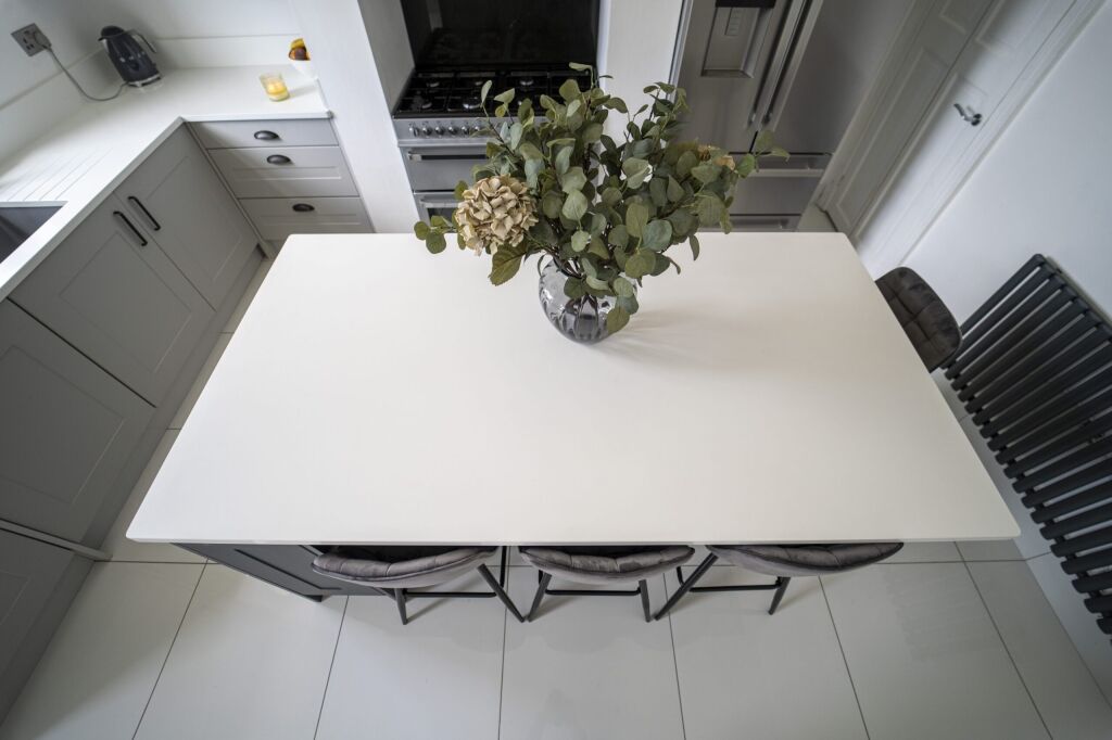 Overhead view of a Classic White Quartz kitchen island showing a smooth bright surface with seating below