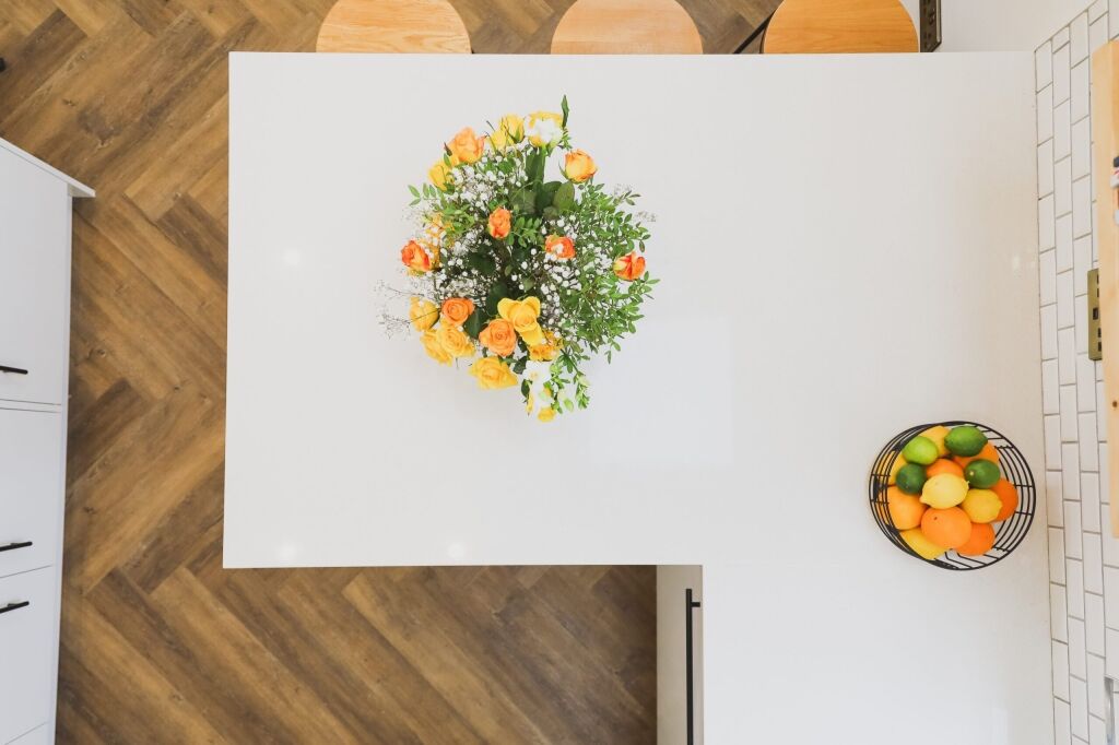 Overhead view of Ice White Quartz worktop surface with a floral arrangement on a smooth white finish