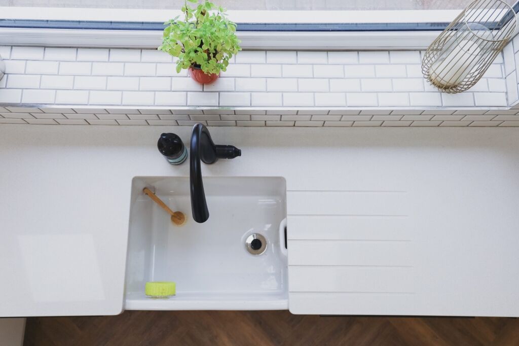 Overhead view of an Ice White Quartz sink run with drainer grooves, inset sink and black tap