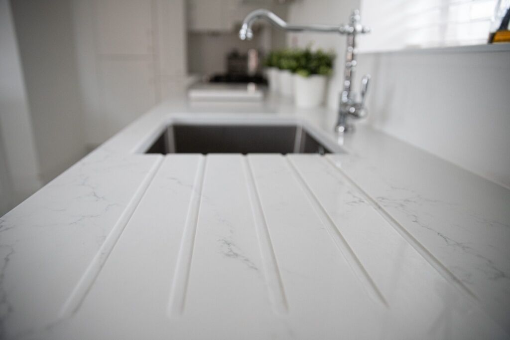 Statuario Bianco Porcelain drainer grooves beside sink showing subtle grey veining