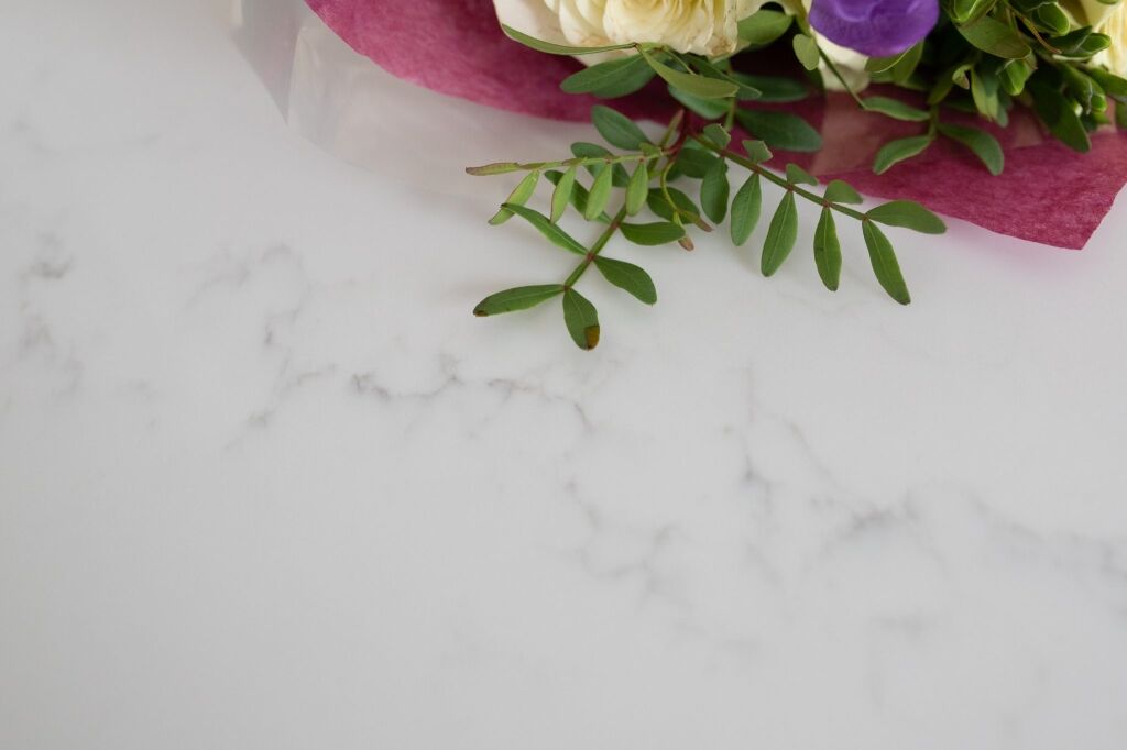 Statuario Bianco Porcelain worktop surface with flowers showing soft grey veining