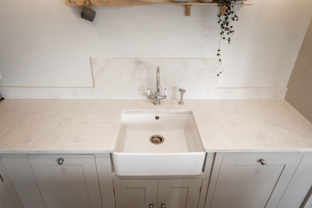 White Concrete Quartz worktop with farmhouse sink and matching upstand showing a pale concrete-effect finish