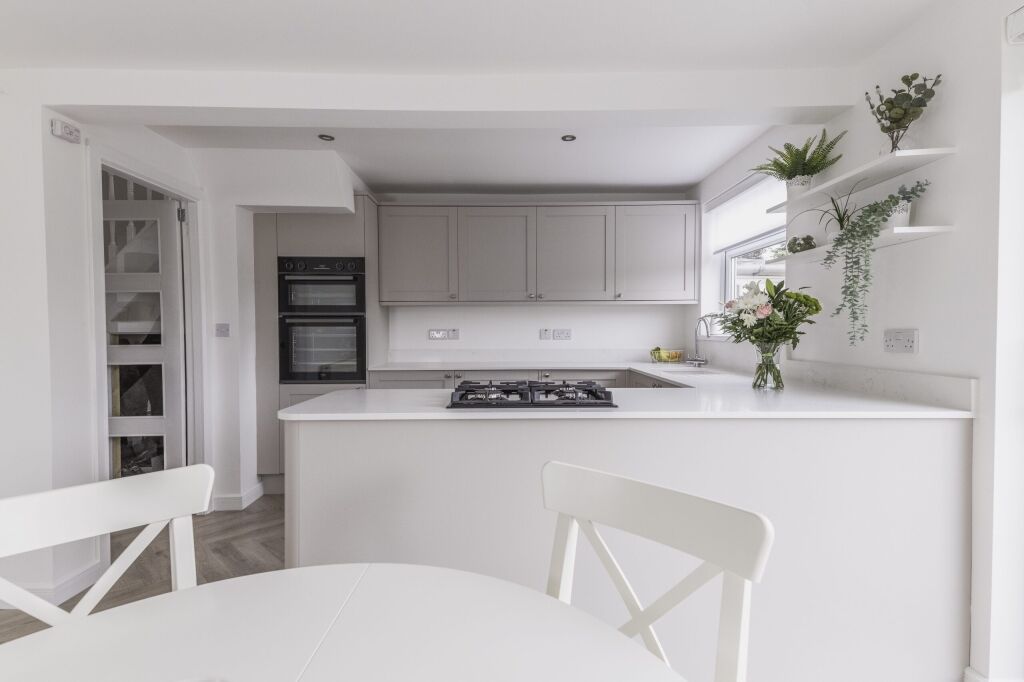Bright kitchen with Bluetta Carrara Quartz island worktop and a hob set into the smooth white surface