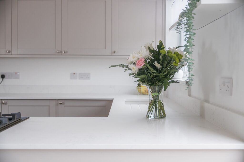 Bluetta Carrara Quartz worktop run with an undermount sink and a smooth bright white surface finish