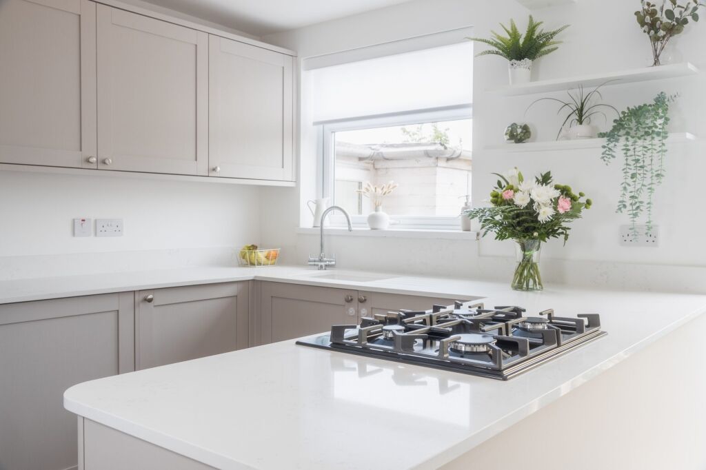Bright kitchen view featuring Bluetta Carrara Quartz worktops with a hob set into the smooth white surface