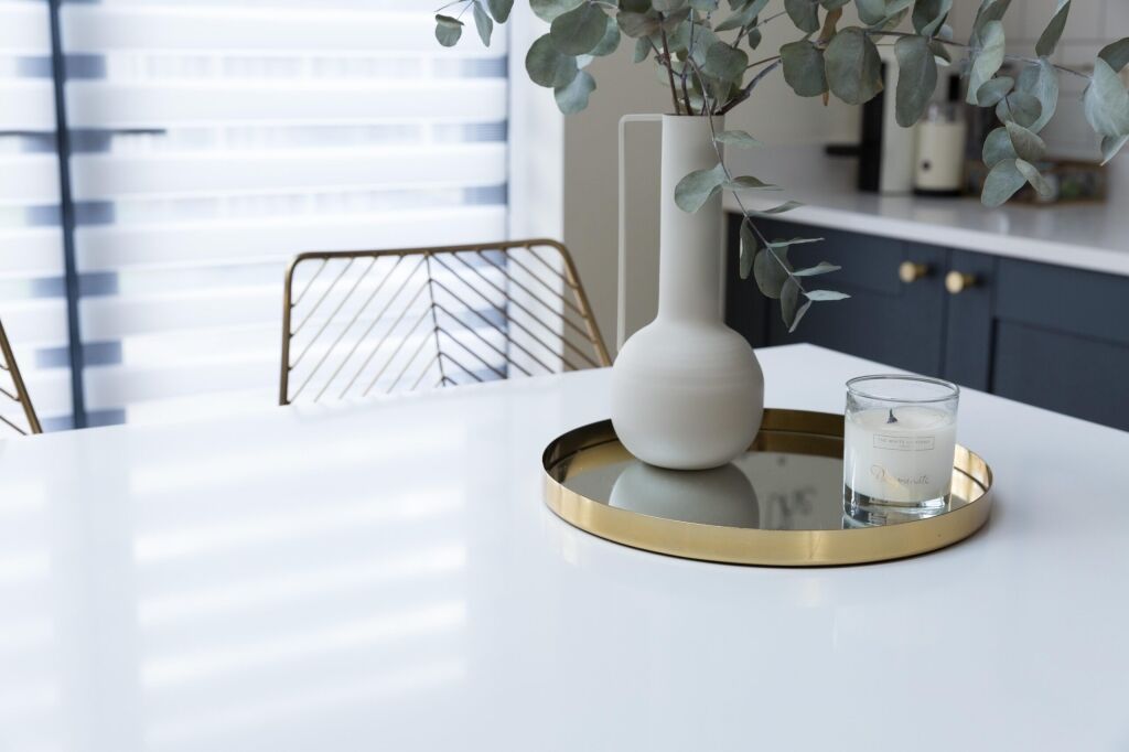 Blanco Zeus Quartz island worktop surface with bright white finish shown with a tray and decorative items