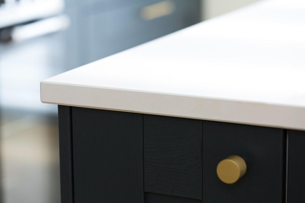 Blanco Zeus Quartz worktop edge close-up showing a crisp white surface and clean profile above dark cabinetry