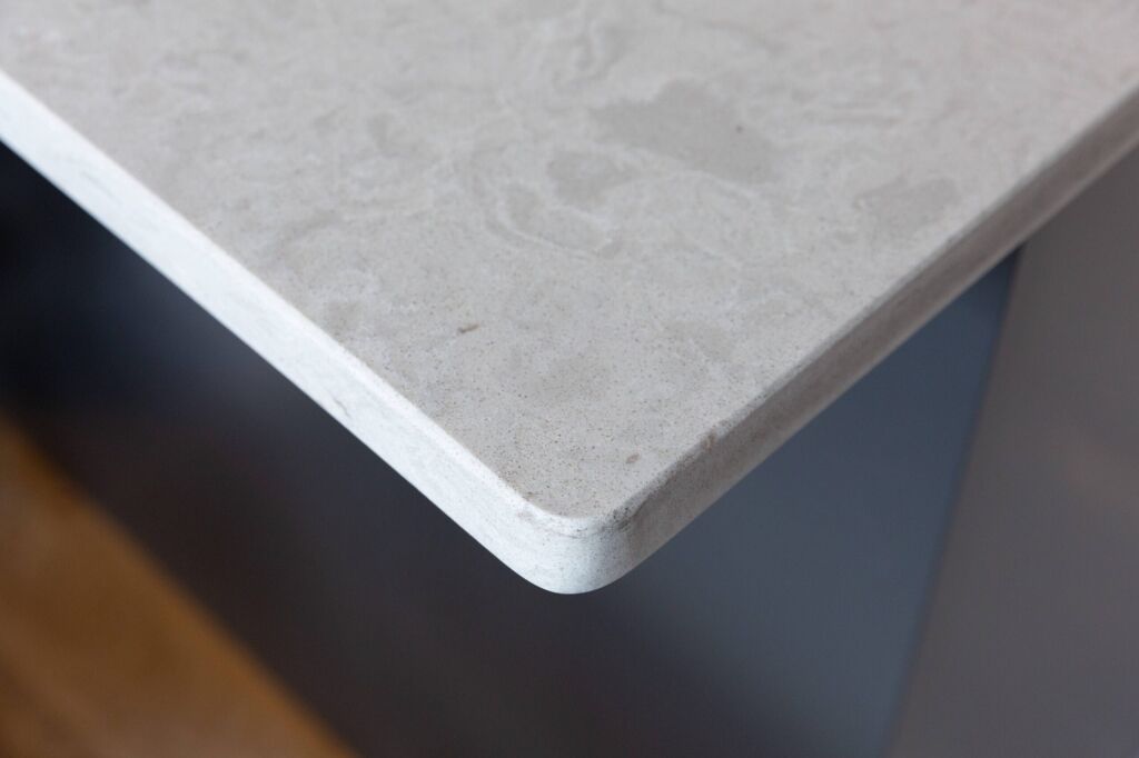 Grey Drift Quartz worktop edge close-up showing rounded corner profile and pale grey stone-effect pattern