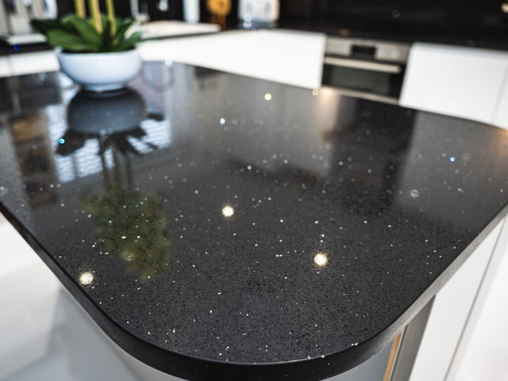 Black Starlight Quartz island worktop close-up showing sparkle flecks and a rounded corner profile