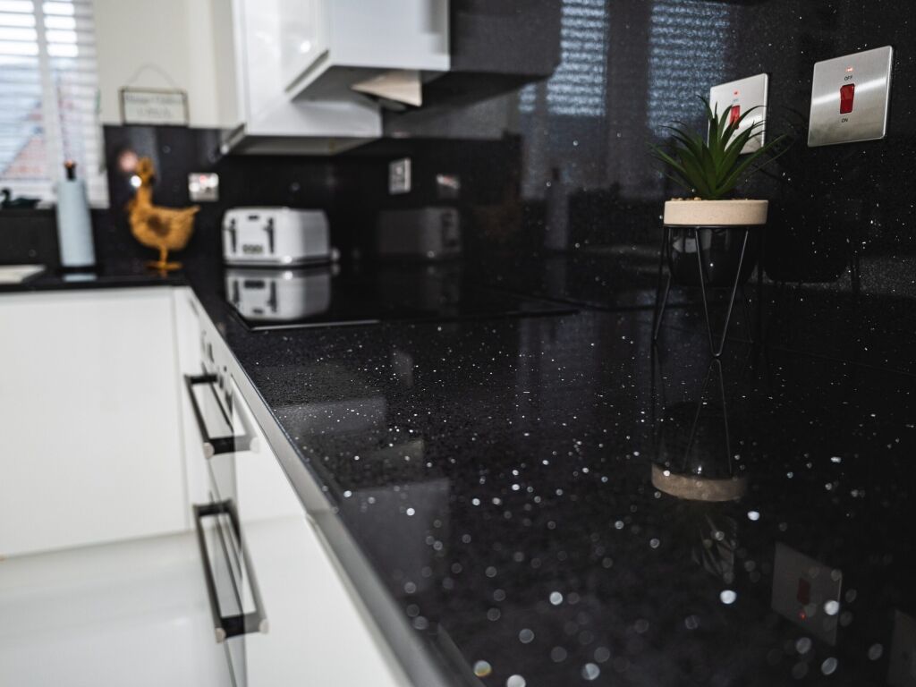 Black Starlight Quartz worktop close-up along a kitchen run showing reflective flecks across the black surface