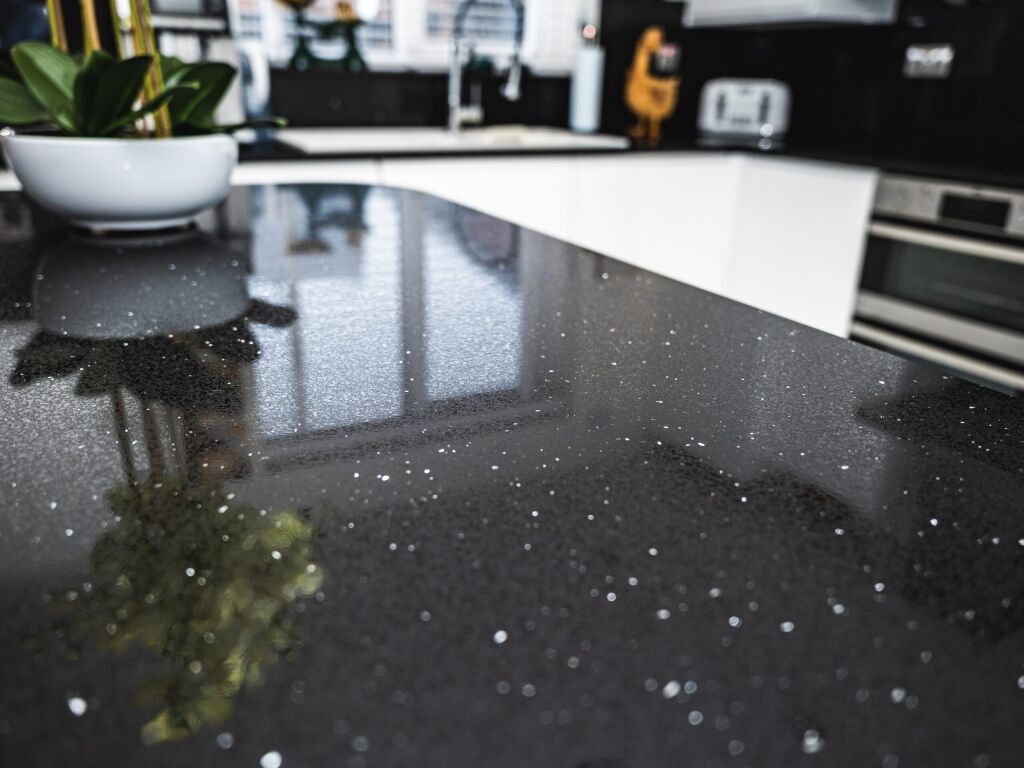 Black Starlight Quartz worktop surface close-up showing sparkle flecks and reflections across the polished black finish