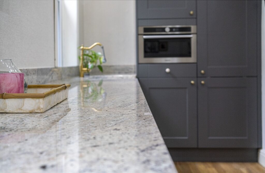 Depth of field shot of Ivory Fantasy Granite worktop surface leading to the sink area, showing the Granite pattern and smooth polished finish.