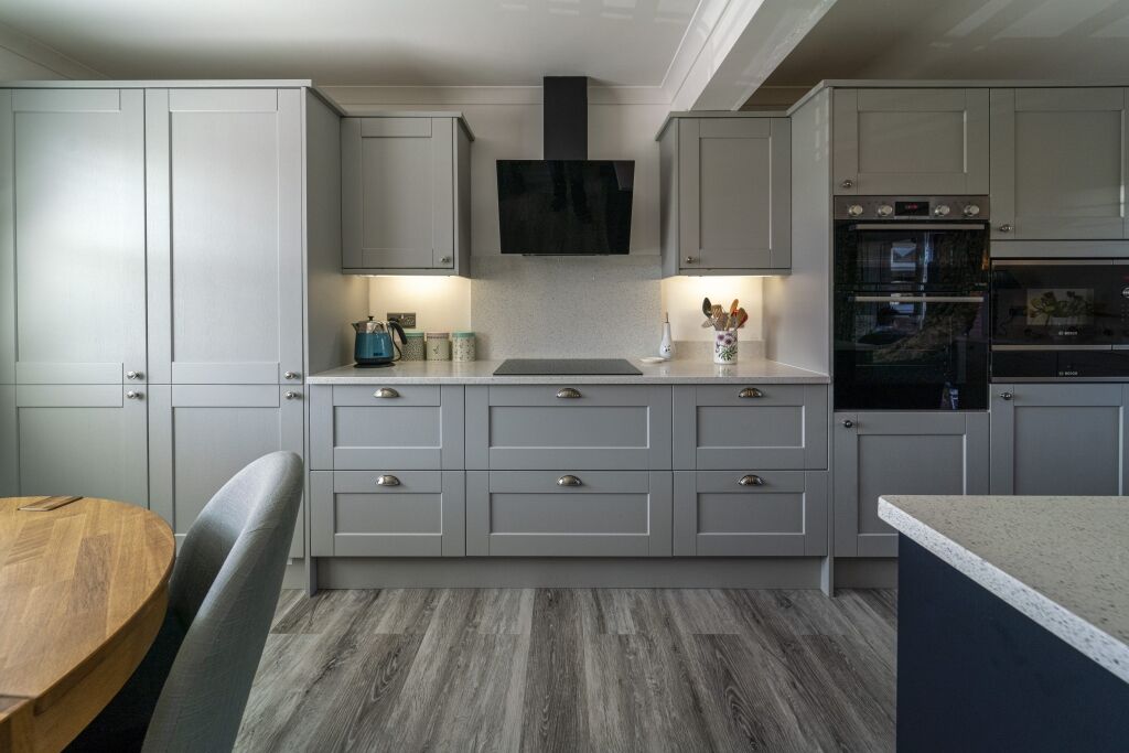 Modern kitchen fitted with White Starlight Quartz worktops and light grey cabinetry