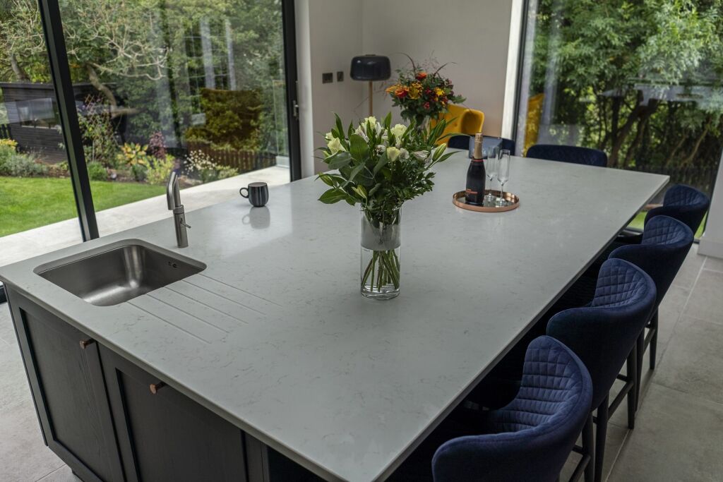 Carrara Quartz worktop beside large window with flower vase