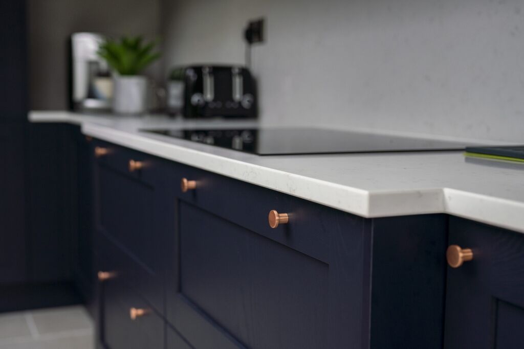 Carrara Quartz island with navy chairs in a modern open kitchen