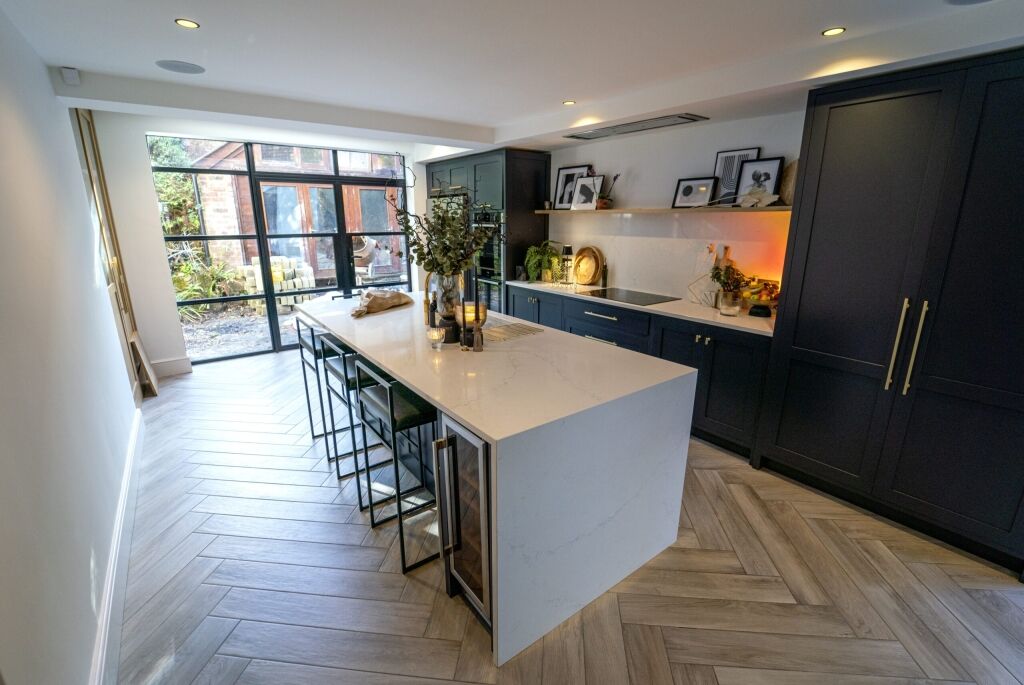 Modern kitchen view showing an Olympus White Quartz island worktop with seating and gentle veining