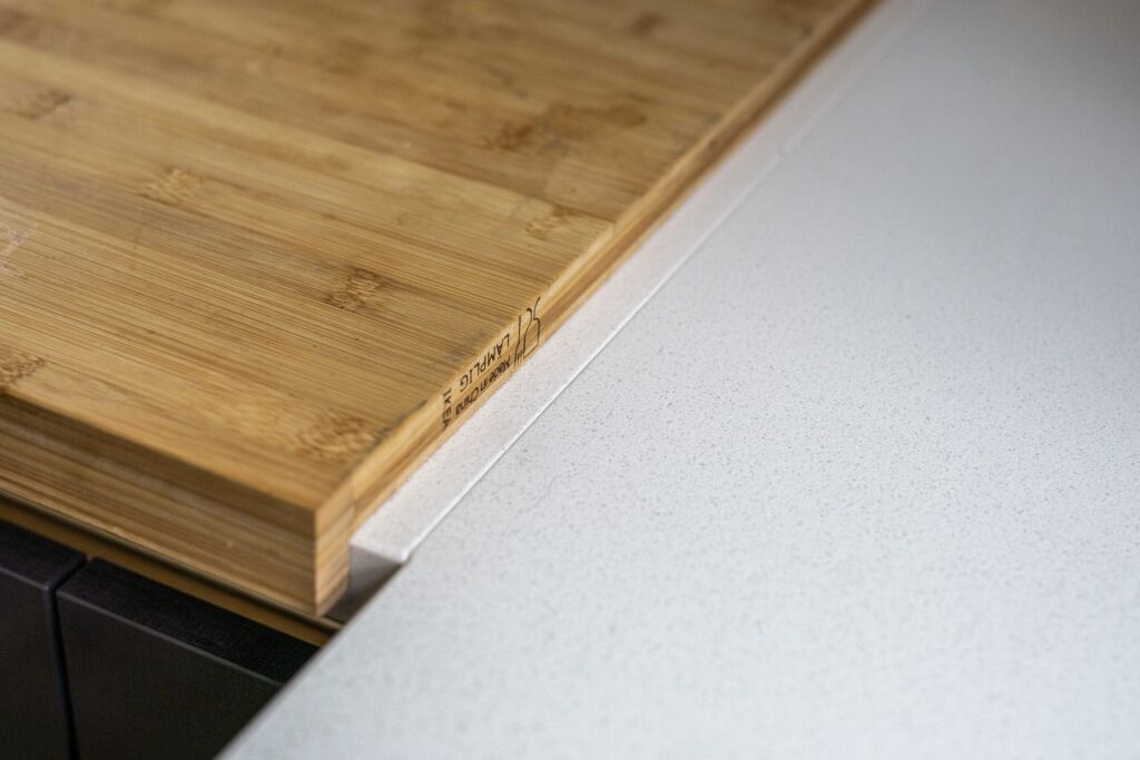 Imperial White Quartz worktop close-up with a wooden chopping board resting on the smooth white surface