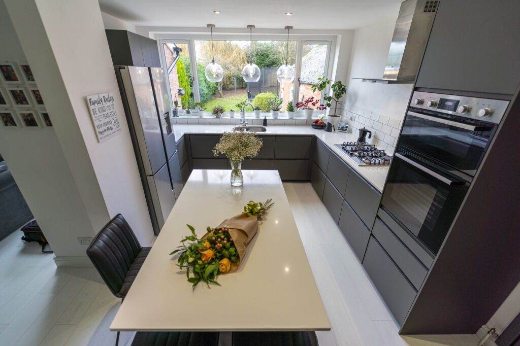 Blanco Zeus Quartz island worktop shown from above with a bright white surface and dining setup in a modern kitchen