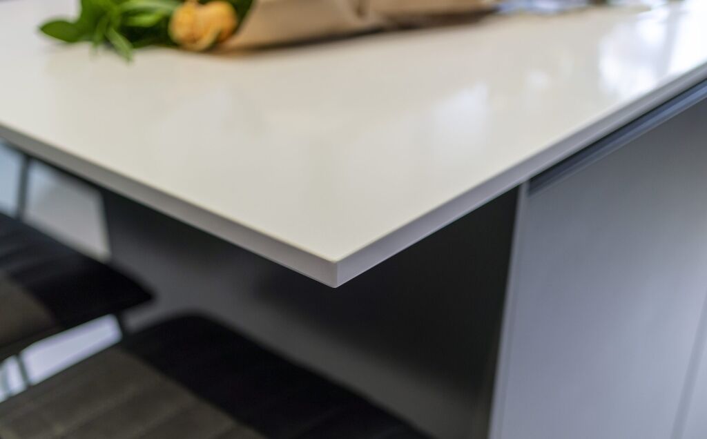 Blanco Zeus Quartz worktop edge close-up showing smooth white surface and clean profile above dark cabinetry