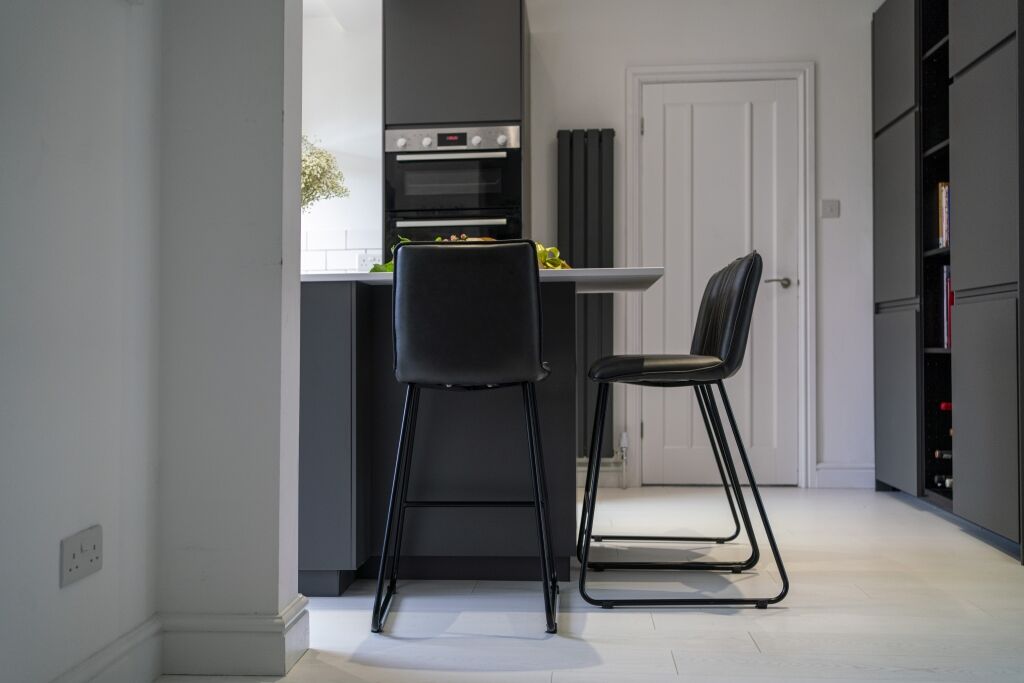Open-plan kitchen view with Blanco Zeus Quartz island worktop and bar seating shown from a side angle