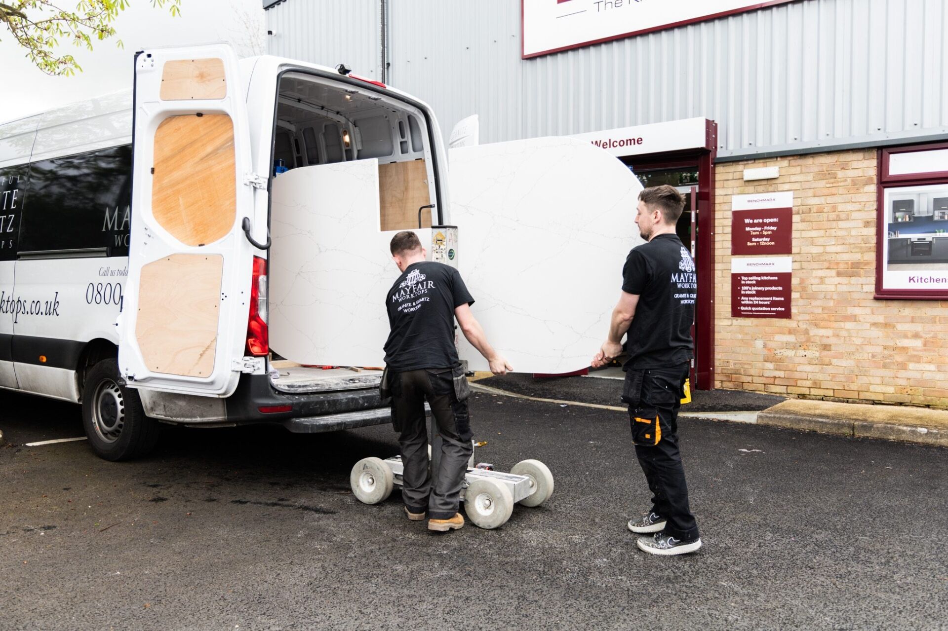 Mayfair Worktops Stonemasons unloading a White Macaubus Quartz worktop slab from a van using a trolley