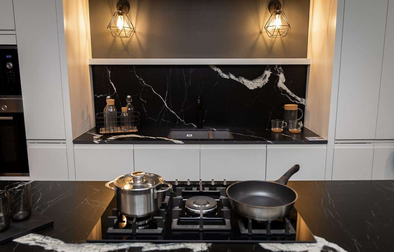 Black Mirage Porcelain splashback and worktop behind gas hob