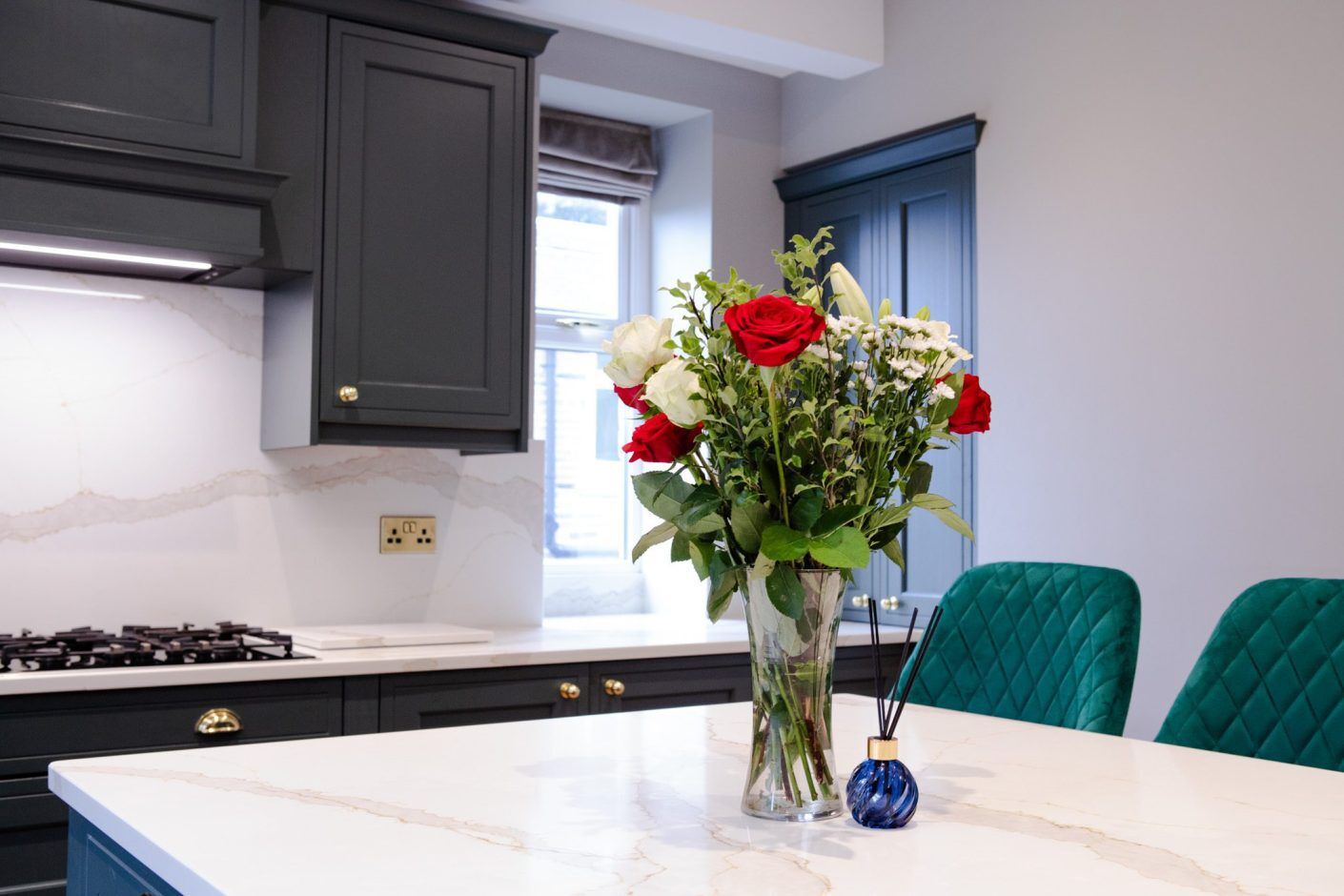 Britannicca Calacatta Quartz island worktop with floral arrangement showing warm grey veining on a bright white surface