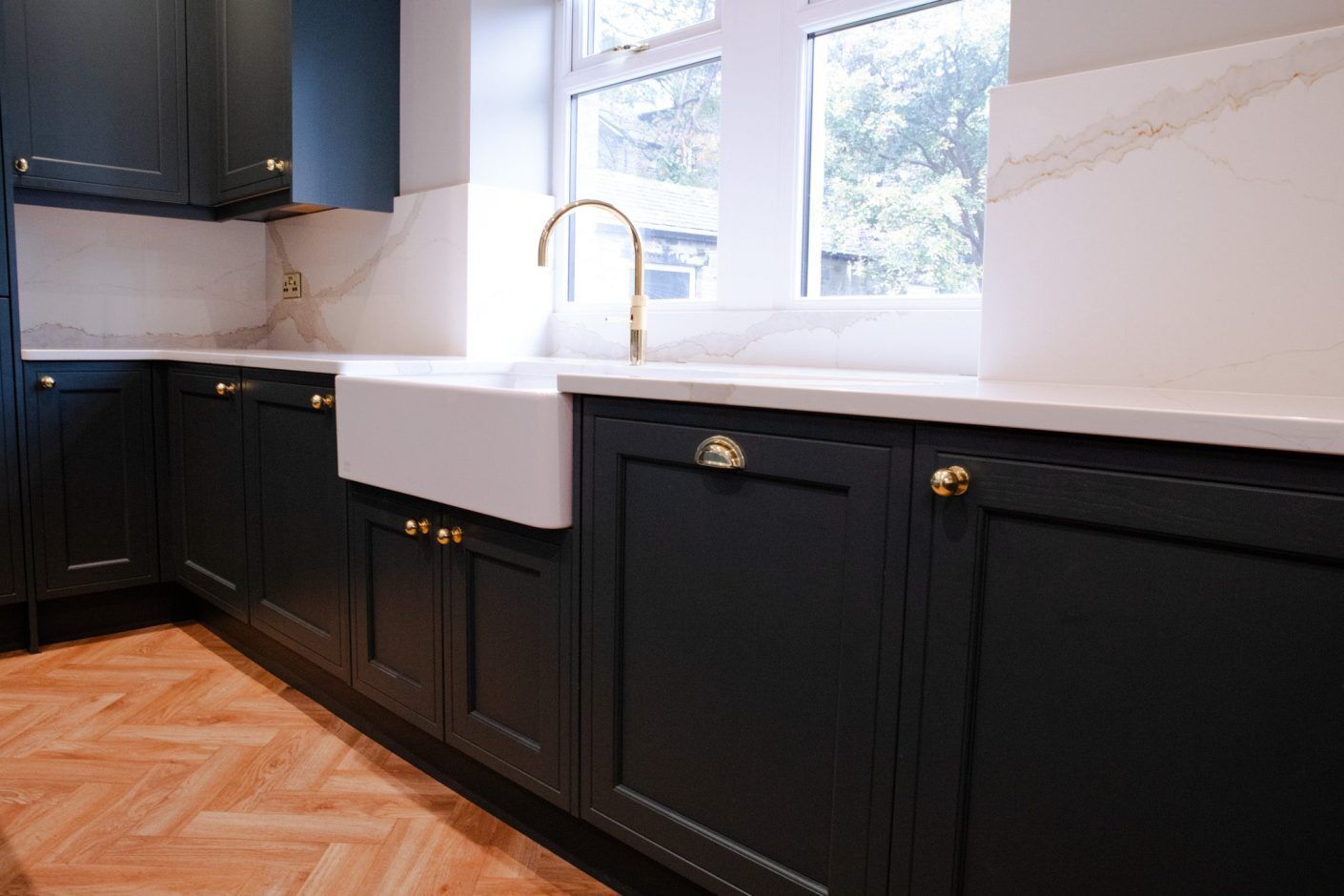 Britannicca Calacatta Quartz worktop run with Belfast sink under a window showing soft warm grey veining