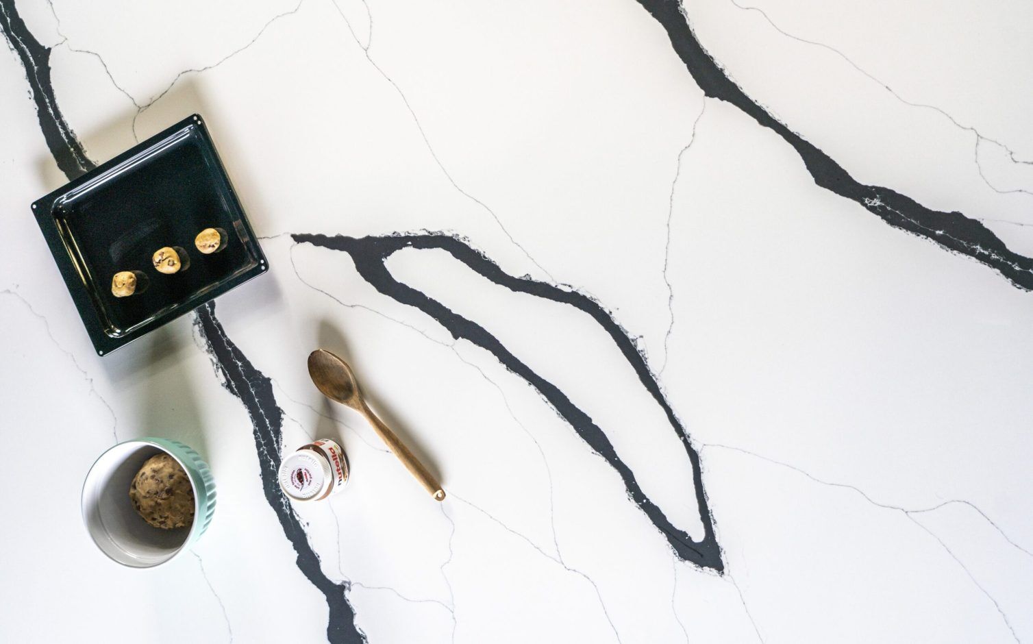 Black Calacatta Quartz slab close-up with sweeping black veins and fine grey linework on a white background