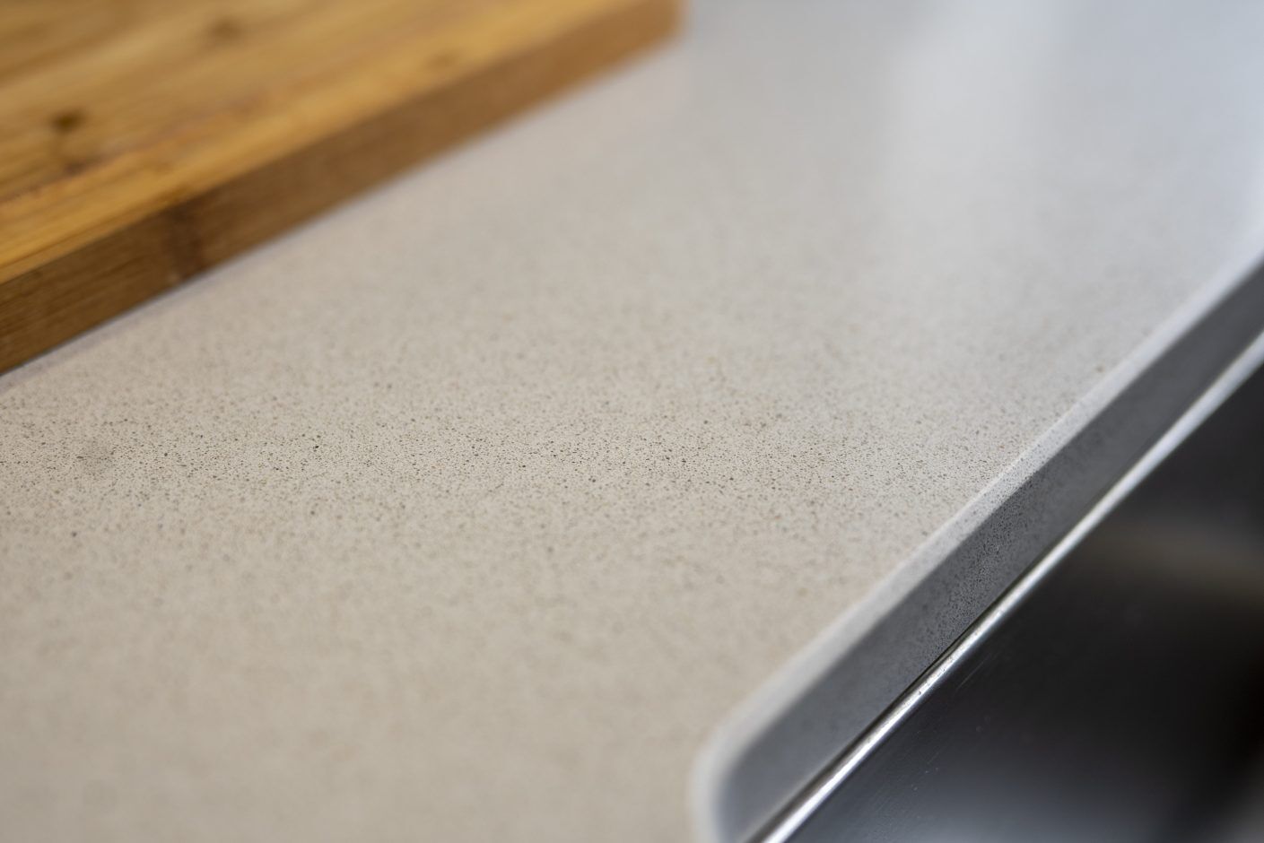 Carnie Quartz worktop edge close-up showing a rounded corner profile and fine speckle texture