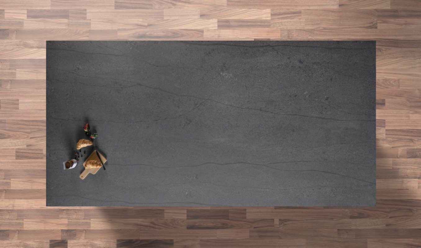 Charcoal Grey Porcelain worktop shown from above on a wood floor setting with dark stone-effect surface and fine movement