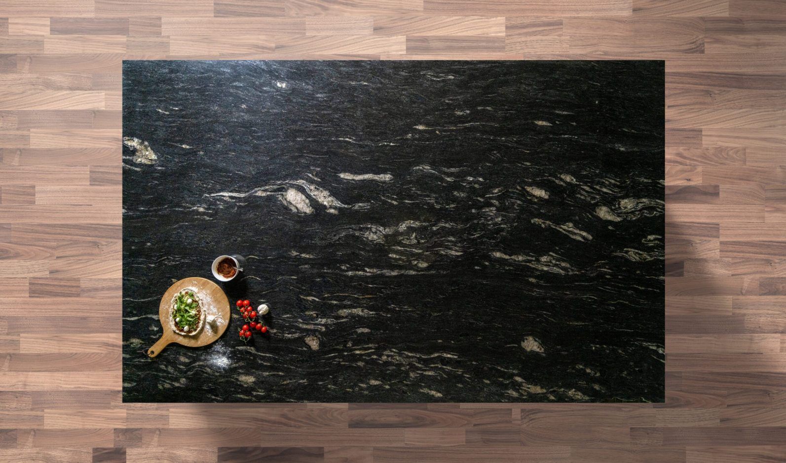 Overhead view of Cosmic Black Granite worktop showing bold natural veining and mineral movement, photographed from above with a small styled tray in the corner.