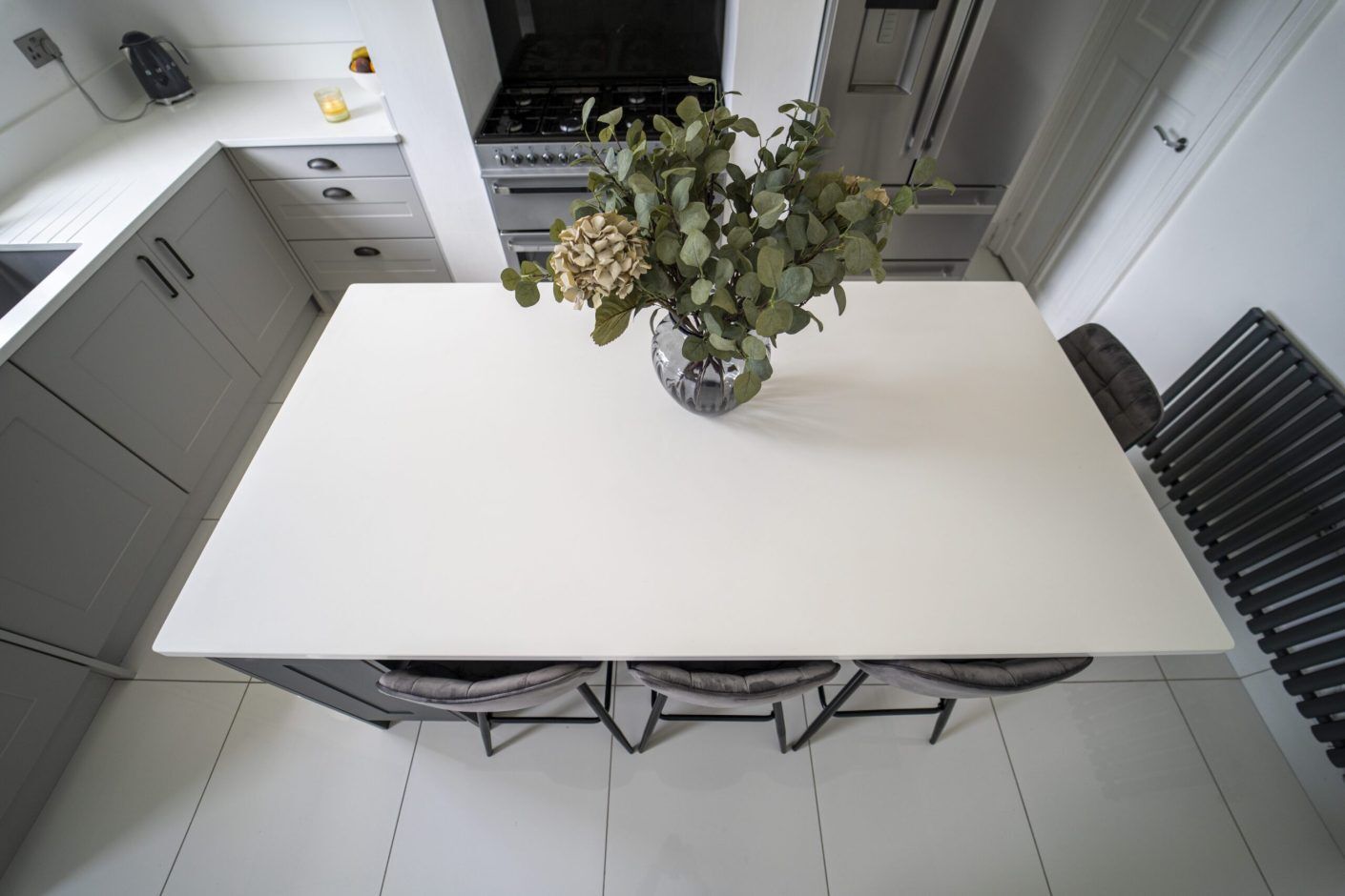 Overhead view of a Classic White Quartz kitchen island showing a smooth bright surface with seating below