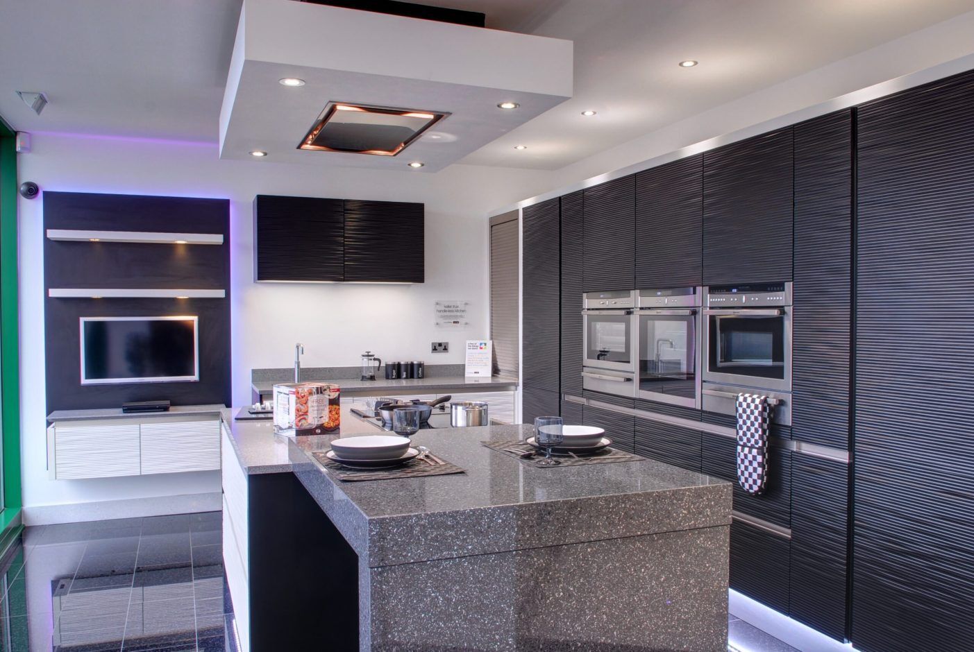 Platinum Quartz island worktop with dark grey speckled surface and waterfall end in a modern kitchen