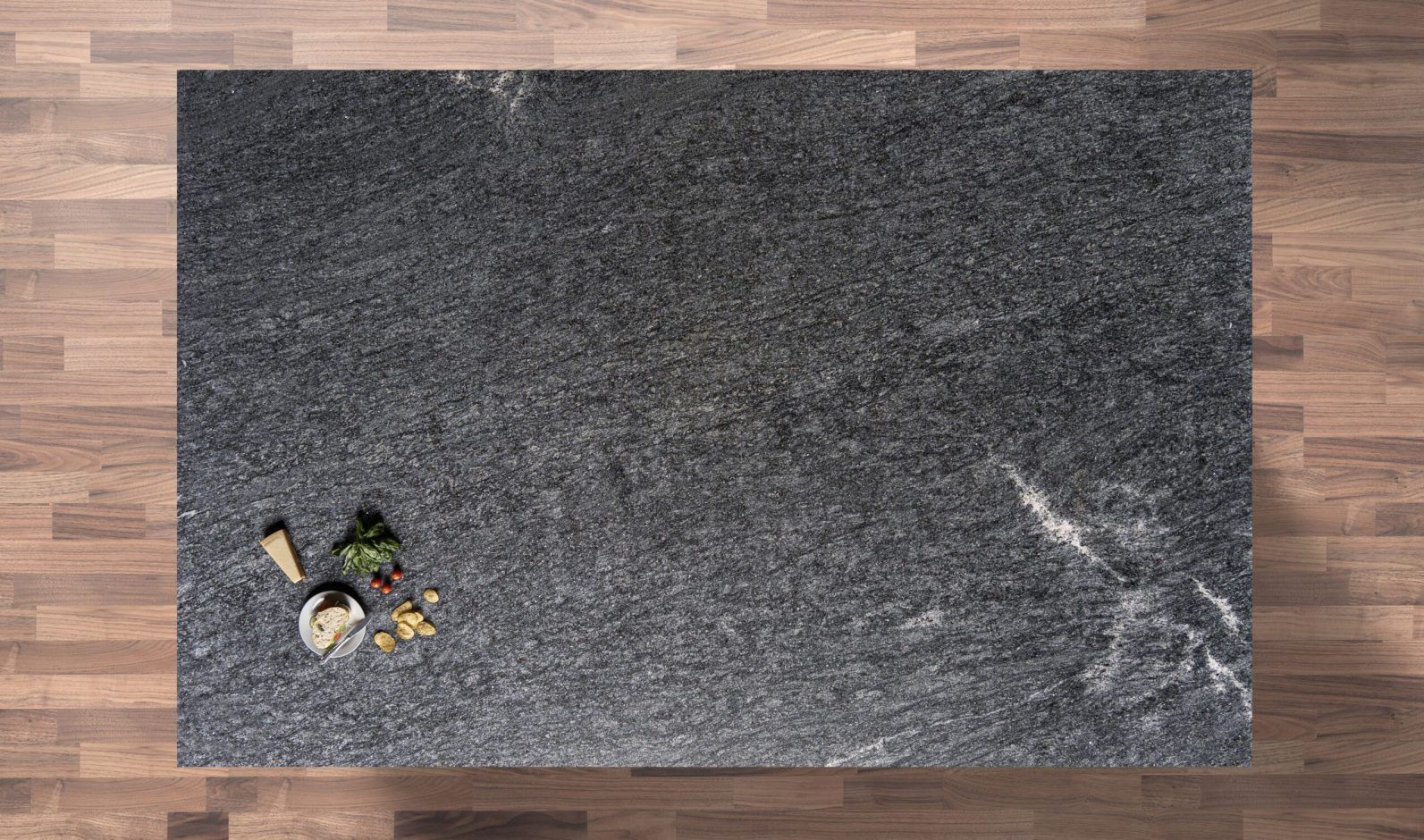 Overhead view of Diamond Galaxy Granite worktop showing a dark speckled pattern and subtle movement, photographed from above with a small styled tray near the edge.