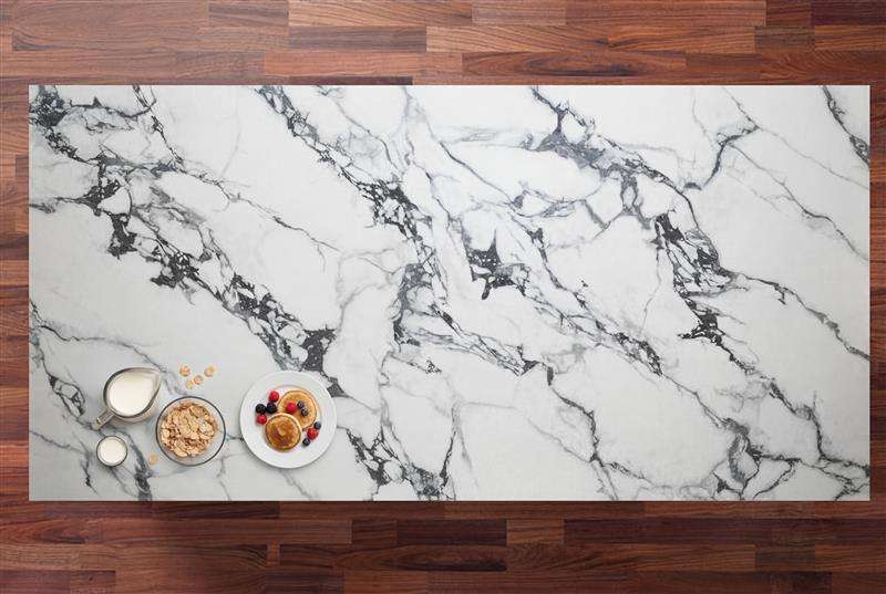 Bulgari Black Porcelain slab with a bright white base and bold black marble effect veining, photographed on a wood background with small props