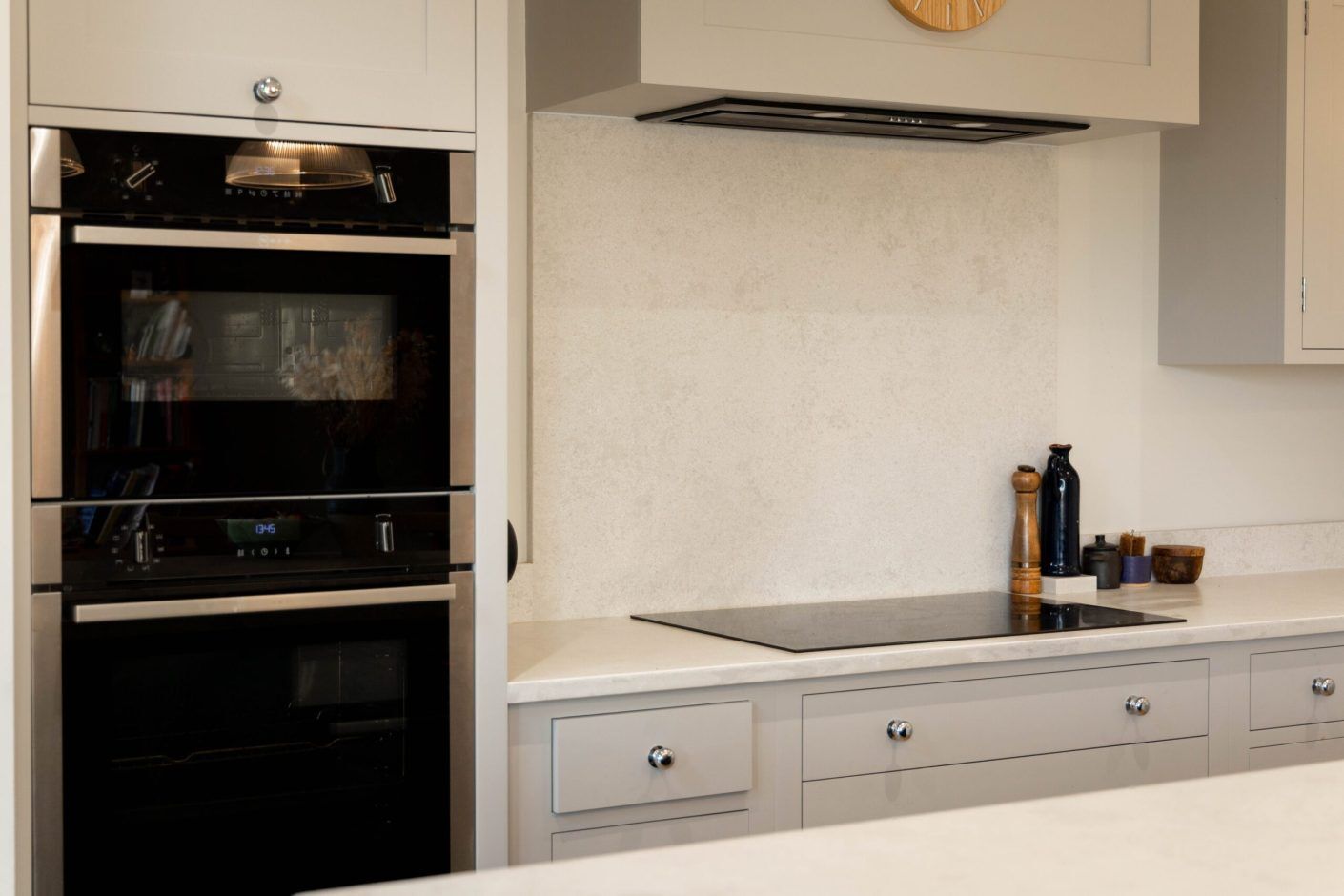 White Concrete Quartz splashback behind the hob showing a pale concrete-effect finish in a shaker kitchen