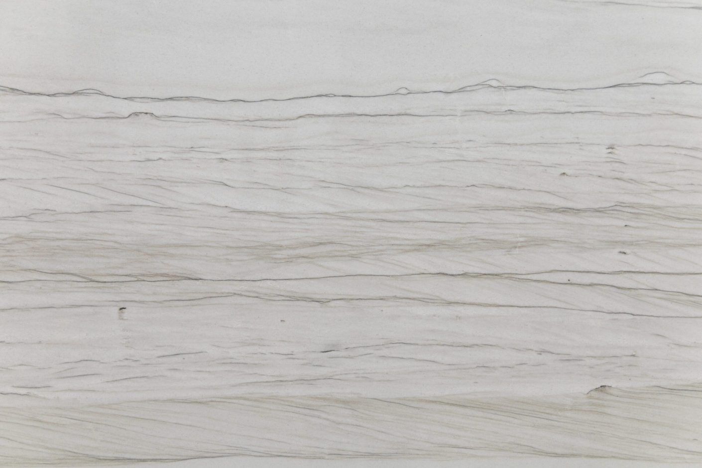 Close up slab photo of Bianco Macaubas Granite showing fine linear grey veining running horizontally across a pale stone surface.