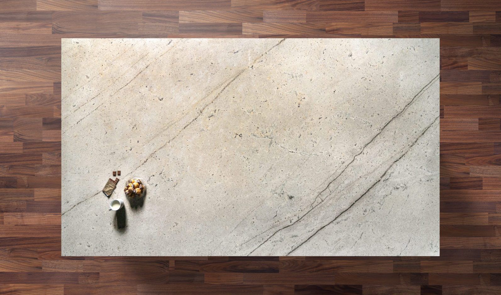 Overhead view of an Ivory Spice Granite worktop showing warm cream tones and soft natural veining, photographed from above with a small styled tray in the corner.