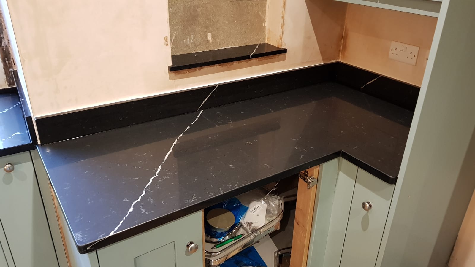 Nero Marquina Quartz corner worktop with upstand showing polished black surface and a single white vein through the run