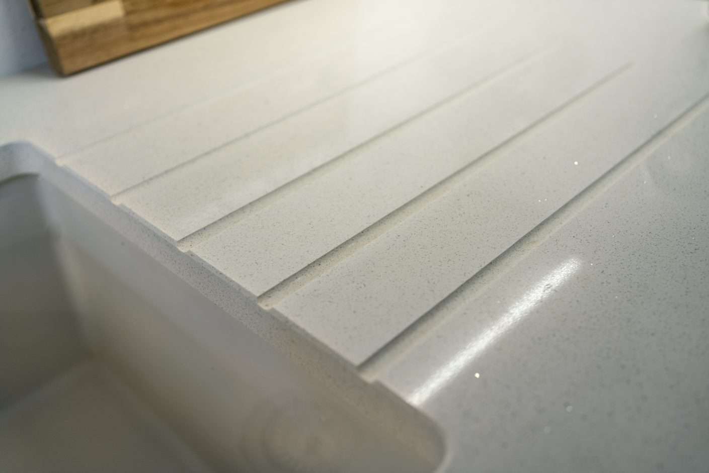 Close up of Aspen Shimmer Quartz drainer grooves with polished finish