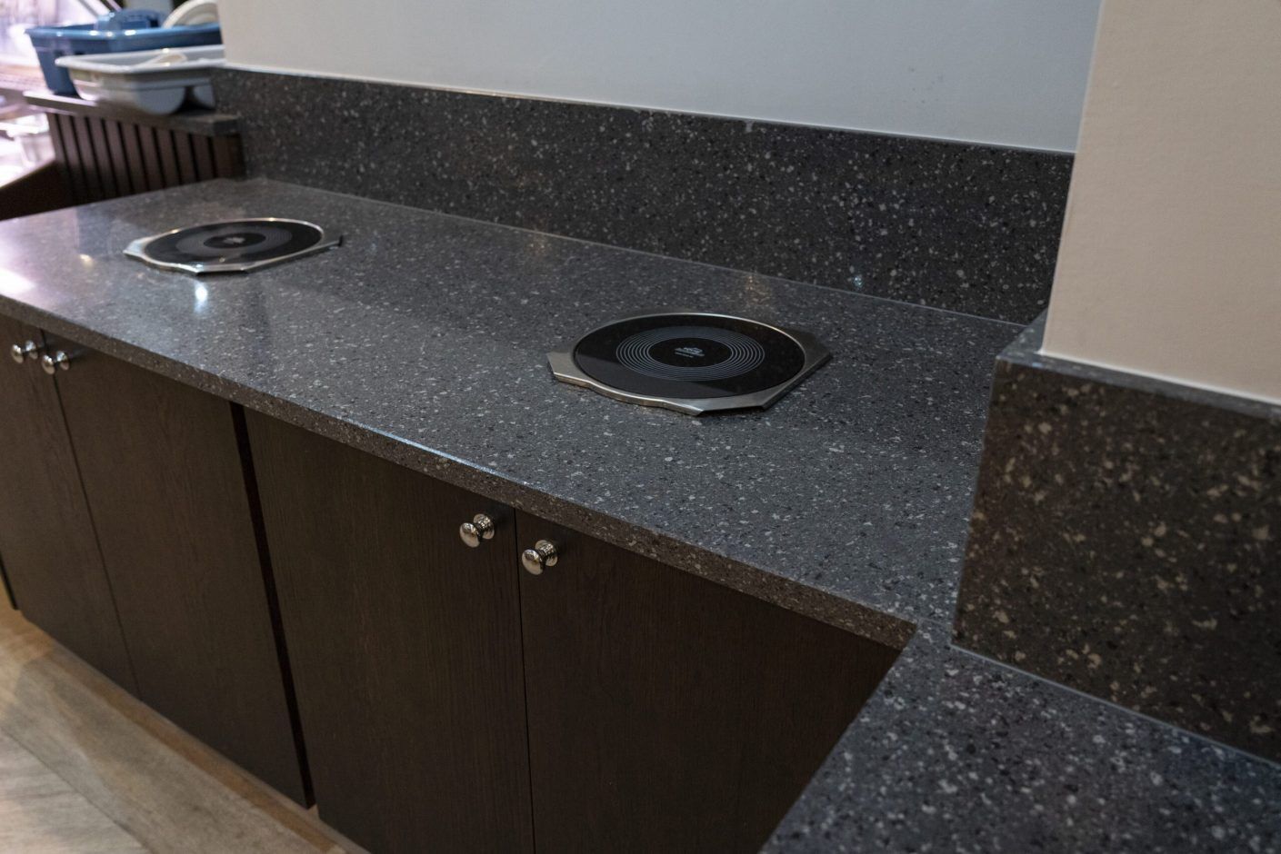 Titanium Quartz worktop close-up showing mid-grey speckled surface with circular sink cut-out and matching upstand